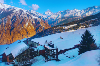 Snow-covered landscape of Auli in Uttarakhand with the Himalayan mountains in the background on a clear winter day